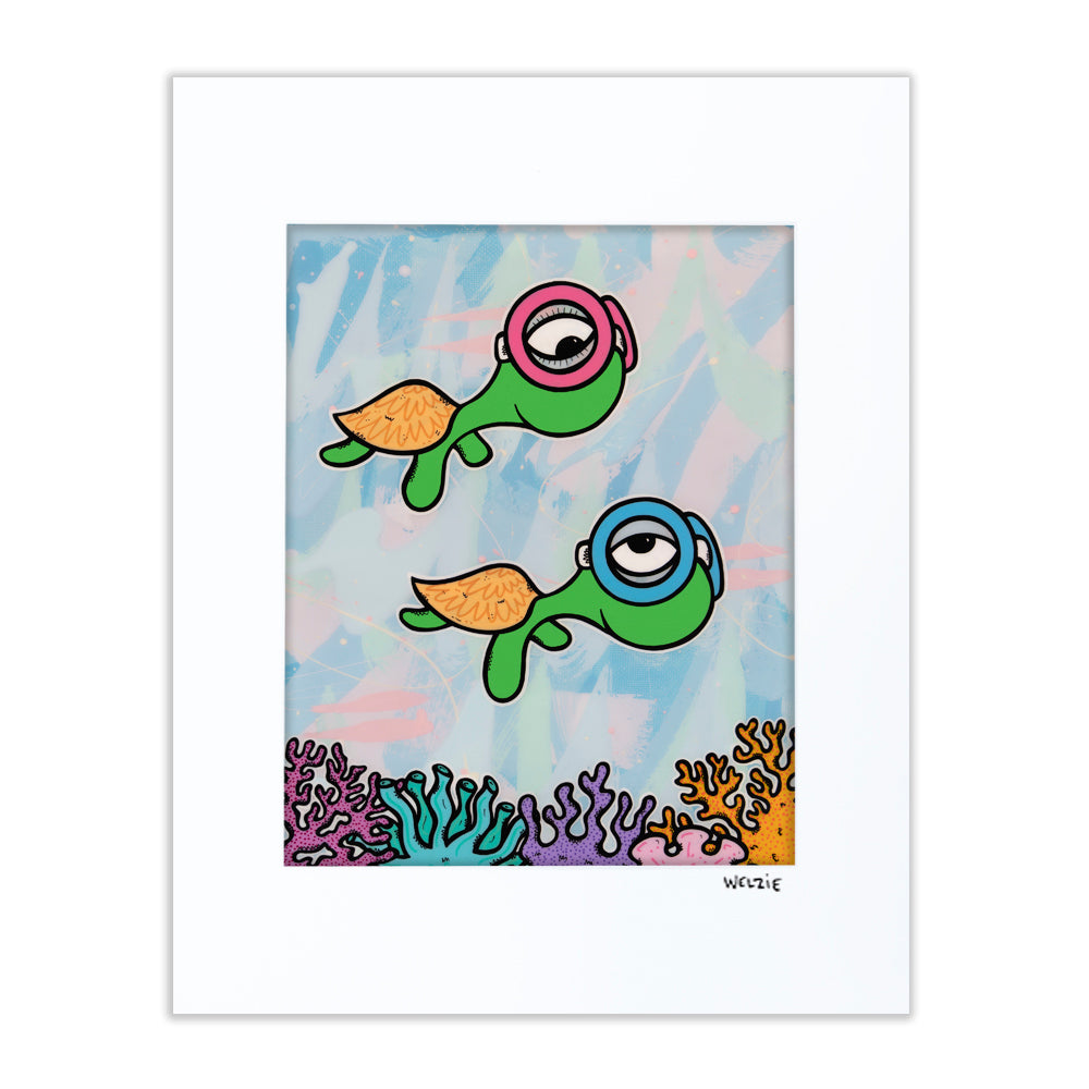 Two green turtle characters wearing snorkel masks over a colorful coral reef — matted fine art print by Maui artist Welzie