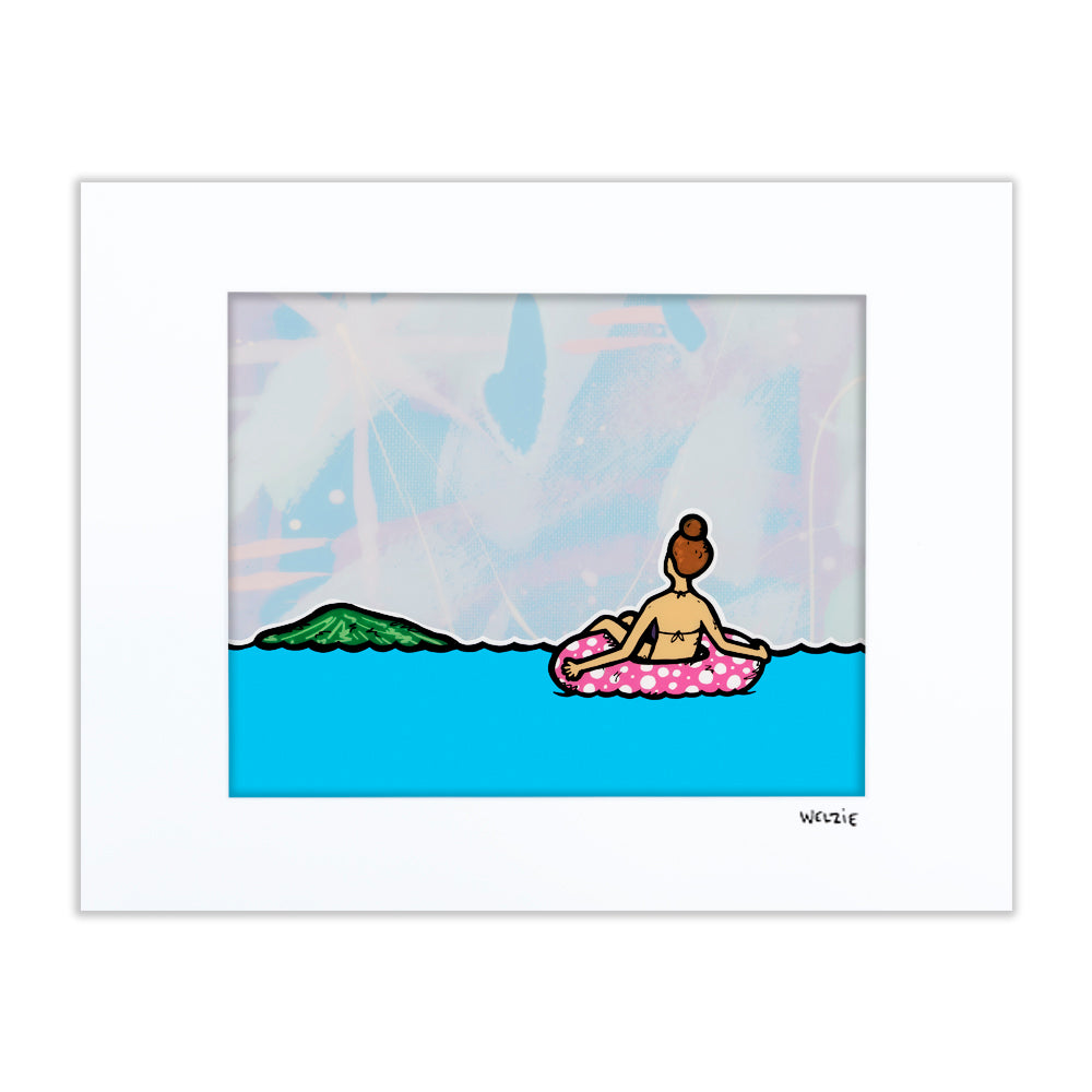 A figure floating on a pink pool float in blue ocean water with a mountain in the background — matted fine art print by Maui artist Welzie