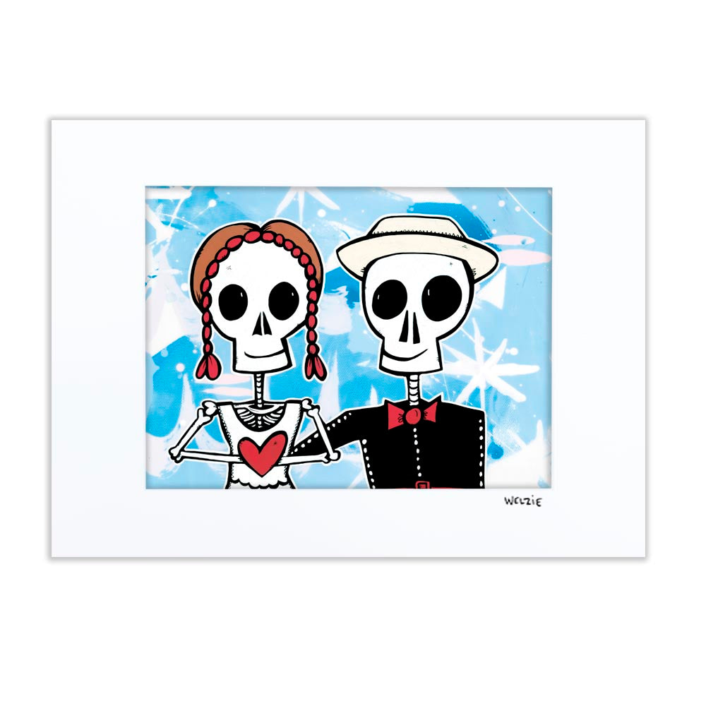 Two skeleton figures holding hands beside a red heart — matted fine art print by Maui artist Welzie