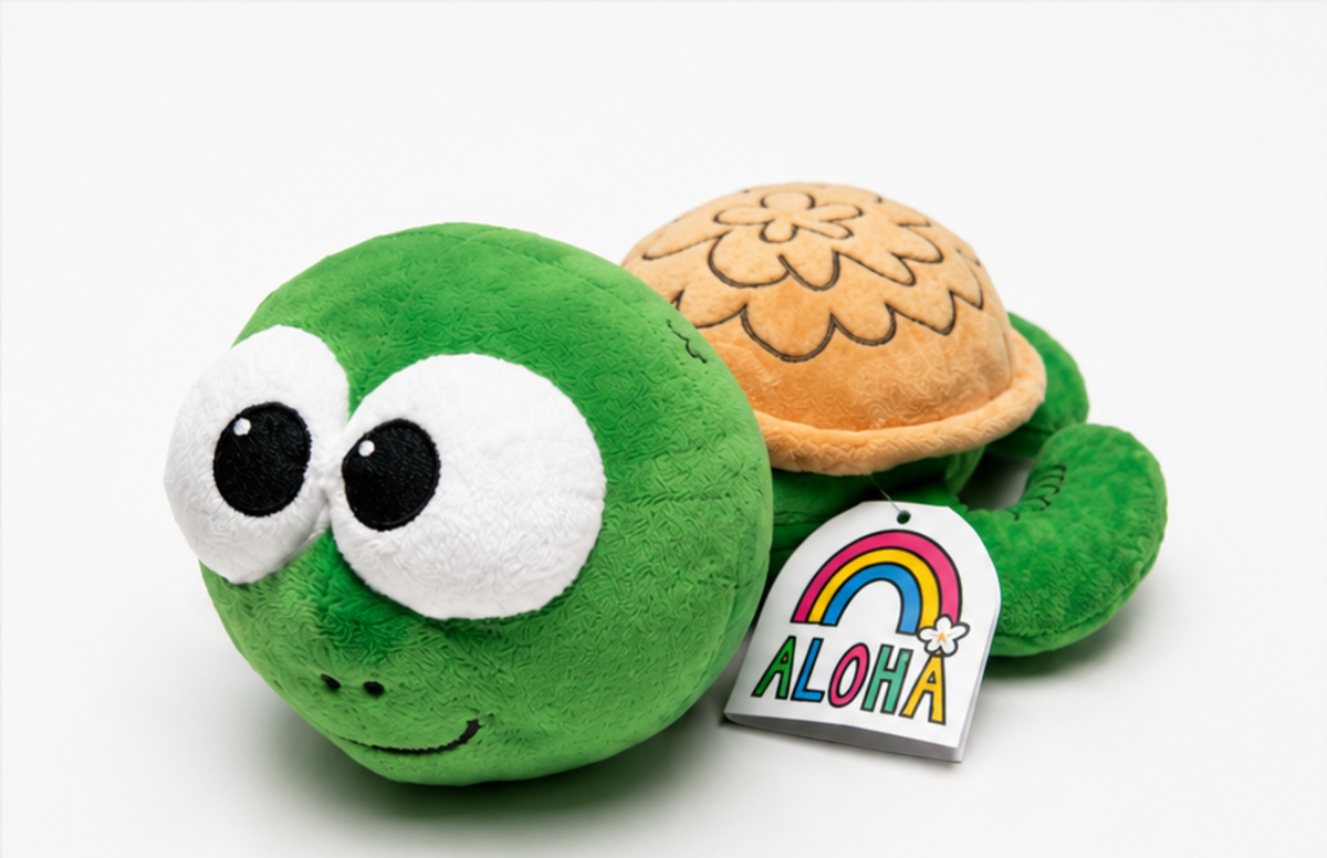 A green plush turtle toy with large white eyes, a tan patterned shell, and a hanging tag that says ALOHA, photographed on a clean white background.